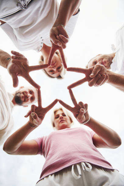 istock Four people fold hands together as a sign of their team work 1140115707