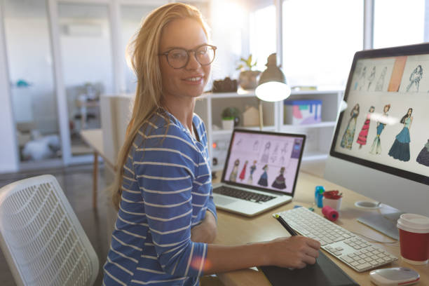 istock Female fashion designer looking at camera while working at desk 1140116942