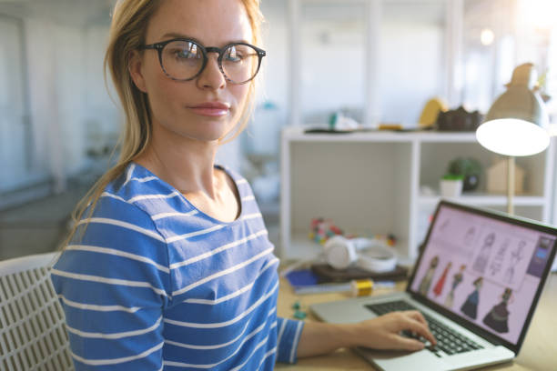 istock Female fashion designer looking at camera while working at desk 1140117045