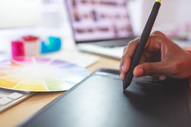 istock Female graphic designer using graphic tablet at desk 1140117817