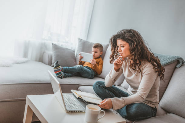 istock Young mother with boy child working on the computer from home 1140117975