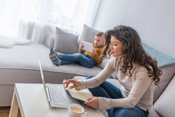 istock Young mother with boy child working on the computer from home 1140117976