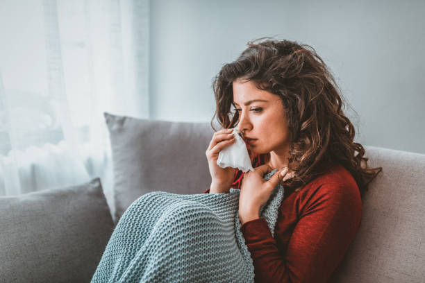 istock Sick woman with headache sitting under the blanket. 1140118132
