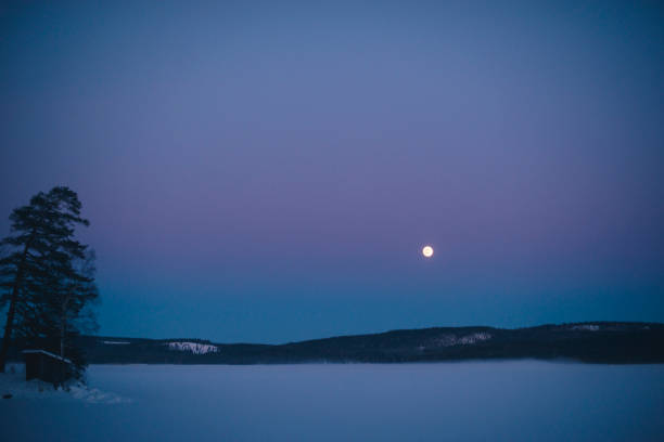 istock Moon over frozen lake after sunset. 1140119743