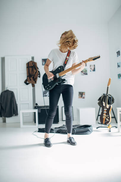 istock Woman playing electric guitar in music studio 1140120656