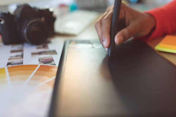 istock Female graphic designer using graphic tablet at desk 1140120704