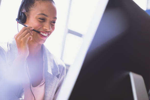 istock Businesswoman talking on headset while working on computer at desk 1140121792