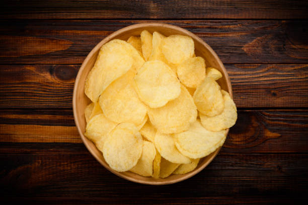 istock Potato chips in bowl on wooden table 1140122033