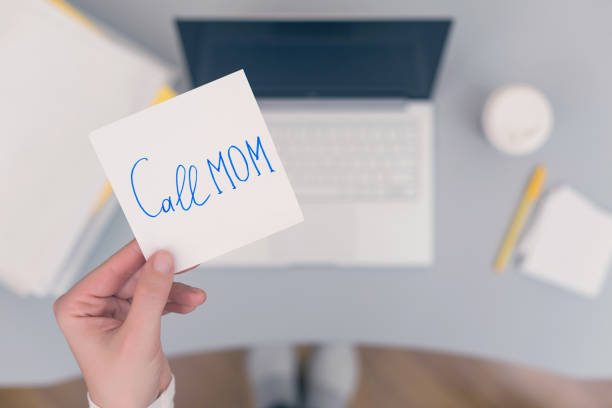 istock Woman clerk is sitting at office table holding note sticker with message 