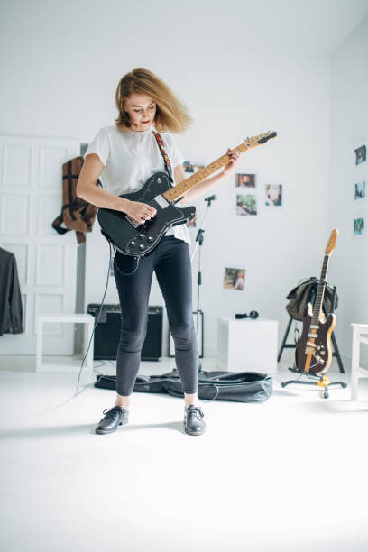 istock Lady playing electric guitar in music studio 1140123422