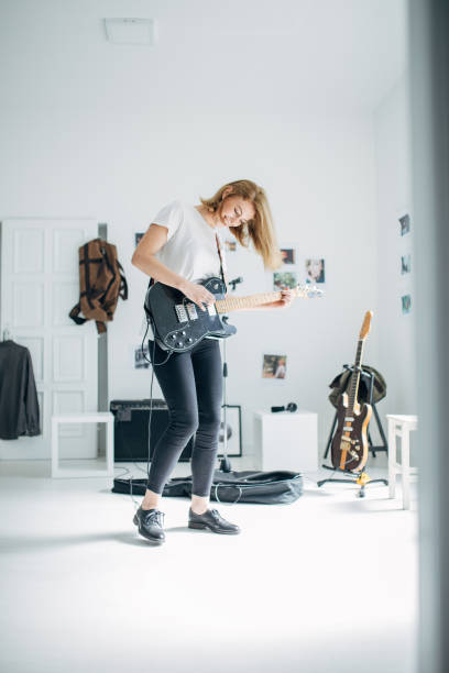 istock Beautiful lady playing guitar in music studio alone 1140123838