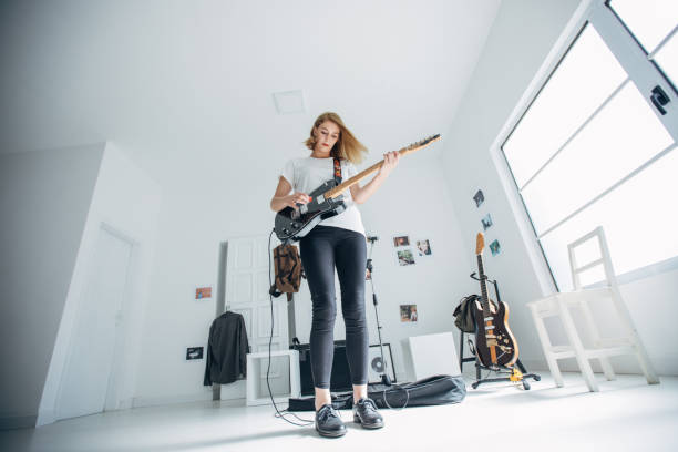 istock Lady playing guitar in music studio alone 1140123863