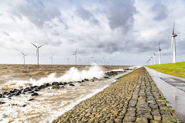 istock Wind turbines in an offshore wind park during a storm with big waves hitting the shore 1140124171