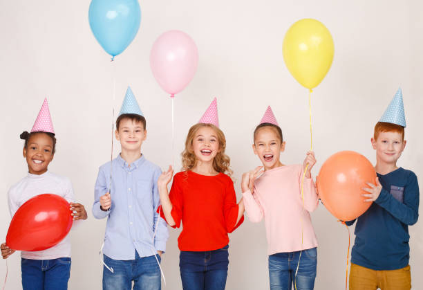 istock Happy children with colourful balloons over wall 1140124210