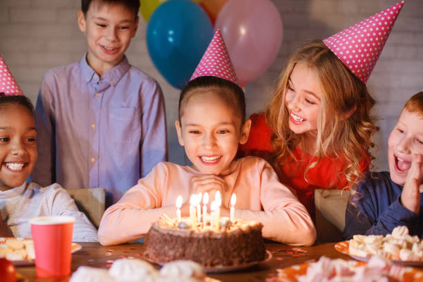 Girl looking at birthday cake with candles Girl looking at birthday cake with candles, having b-day party birthday candle stock pictures, royalty-free photos & images