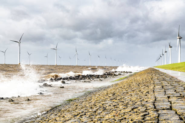 istock Wind turbines in an offshore wind park during a storm with big waves hitting the shore 1140124230