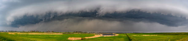 Storm clouds over the Reevediep waterway near Kampen in the IJsseldelta Storm clouds over the Reevediep waterway near Kampen in the IJsseldelta. The arcus cloud with thunder and lightning is moving fast over the green landscape. Wide panorama image. ijssel photos stock pictures, royalty-free photos & images