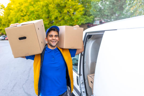 smiling young male postal delivery courier man in front of cargo van delivering package - postal worker truck driver delivering delivery person imagens e fotografias de stock