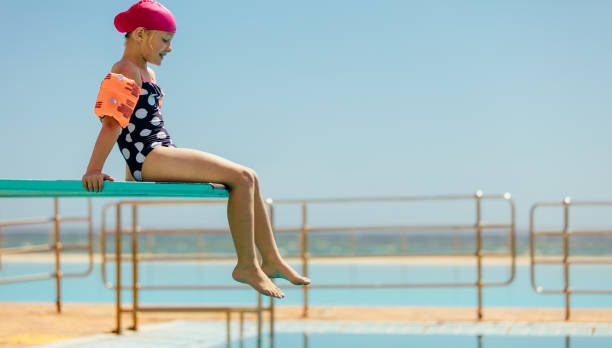 istock Girl on diving spring board 1140125286