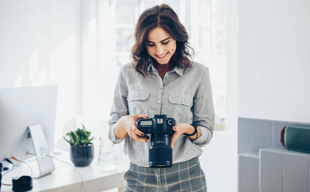 istock Photographer checking pictures on dslr camera 1140126546
