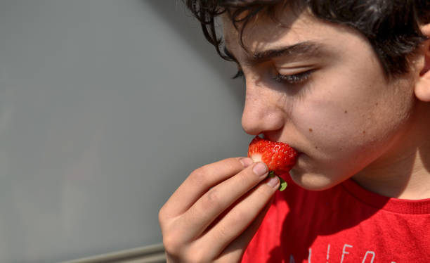istock Caucasian child who is eating a strawberry 1140126779