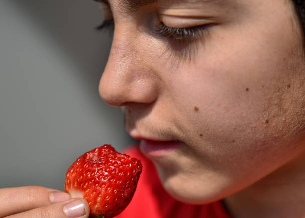 istock Caucasian child who is eating a strawberry 1140126839