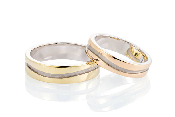 istock Pair of two tone gold wedding rings with wave design isolated on white background 1140127082