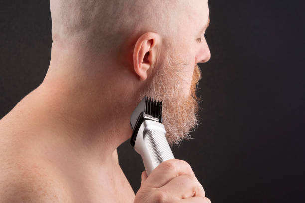 istock Bearded man with trimmer to adjust beard in hand 1140128483