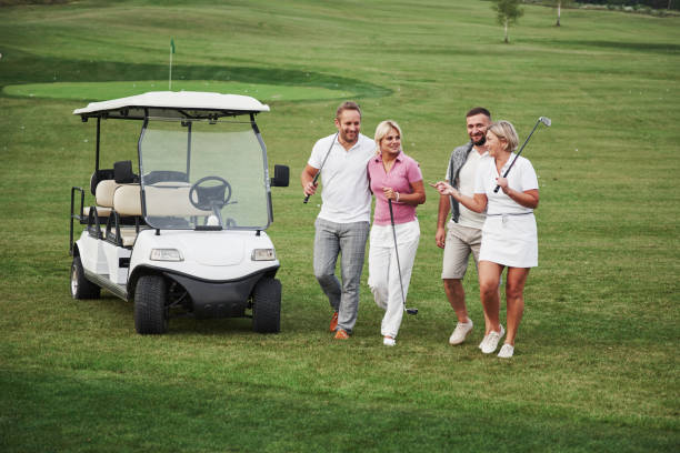 젊은 부부는 재생 준비. 웃는 친구 들의 그룹이 골프 카트에 구멍을 내 렸 습니다. - beautiful golf course relaxation happiness 뉴스 사진 이미지