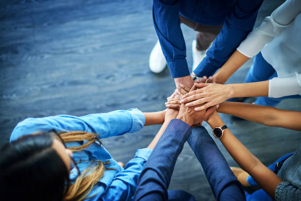 Nothing can beat united minds High angle shot of a group of colleagues joining their hands together in unity determination stock pictures, royalty-free photos & images