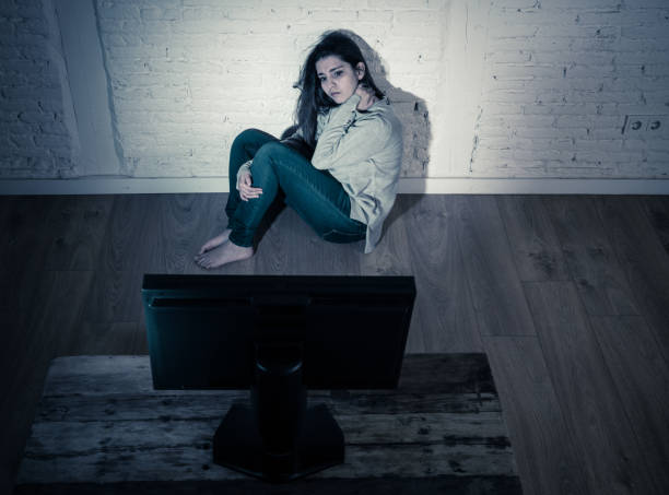 istock Dramatic portrait of sad scared young woman alone on the ground staring a computer suffering bullying and harassment. Being online abused by stalker feeling desperate in Internet problem concept. 1140129932