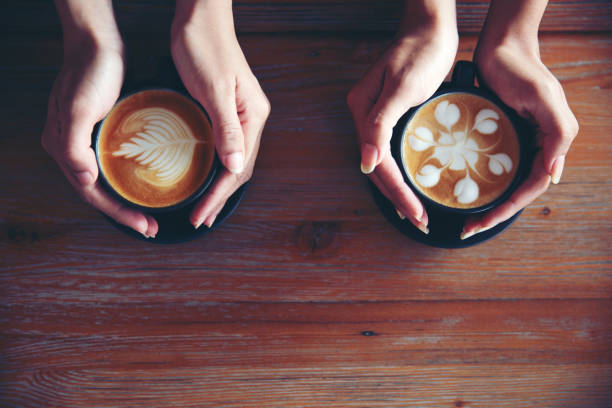 istock Female hands holding cups of coffee on rustic wooden table background 1140130861
