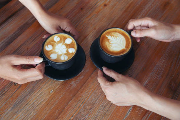 istock Female hands holding cups of coffee on rustic wooden table background 1140131962