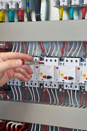 worker-checks-the-operation-of-the-electric-cabinet-after-its