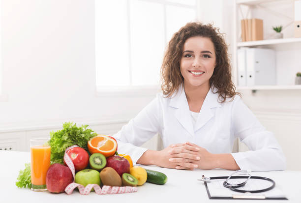 istock Dietitian working on diet plan at office, smiling at camera. 1140134129