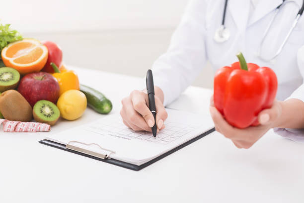 istock Female nutritionist doctor writing vegetable diet plan 1140134132