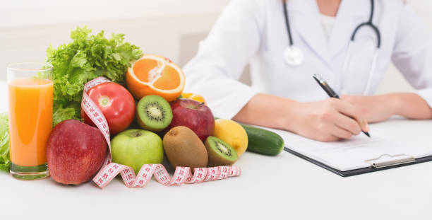 istock Female nutritionist doctor writing vegetable diet plan 1140134142