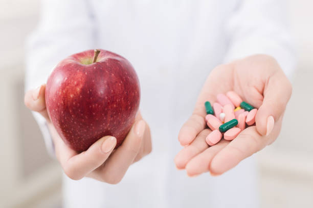 istock Doctor holding apple and pills in hands 1140134148