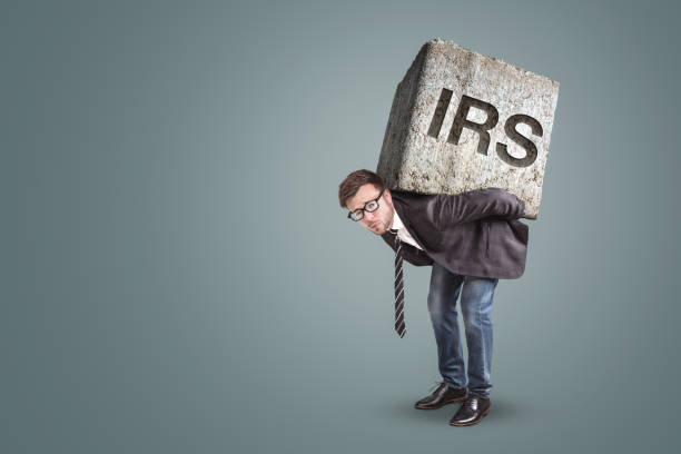 istock Entrepreneur carrying a large stone with engraved IRS letters 1140135814