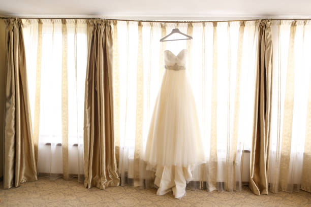 istock Wedding dress hanging by the window 1140137855