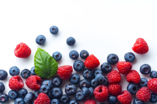 istock Raspberries and blueberries isolated on white background with copy space 1140137979