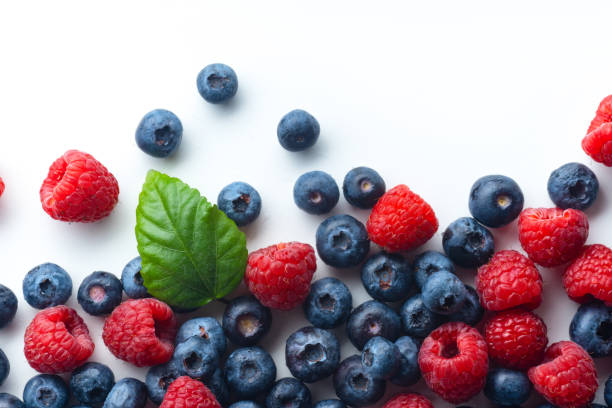 istock Raspberries and blueberries isolated on white background with copy space 1140137983