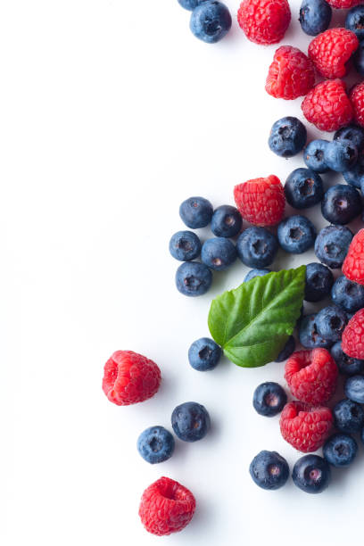 istock Raspberries and blueberries isolated on white background with copy space 1140137989