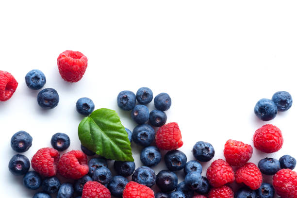 istock Raspberries and blueberries isolated on white background with copy space 1140137990