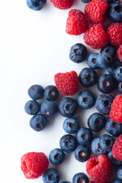 istock Raspberries and blueberries isolated on white background with copy space 1140137992