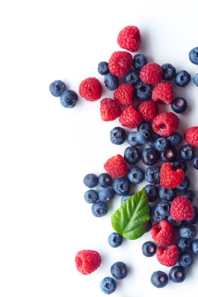 istock Raspberries and blueberries isolated on white background with copy space 1140137994
