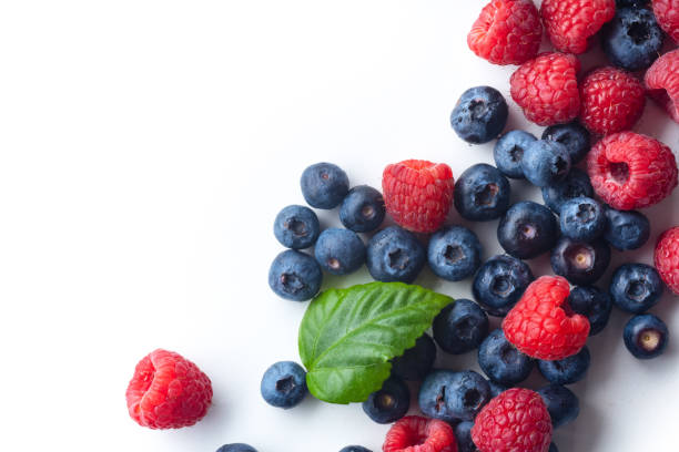 istock Raspberries and blueberries isolated on white background with copy space 1140137995