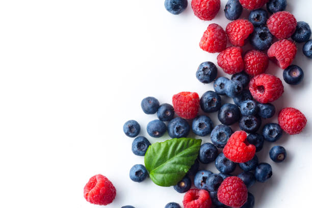 istock Raspberries and blueberries isolated on white background with copy space 1140138006