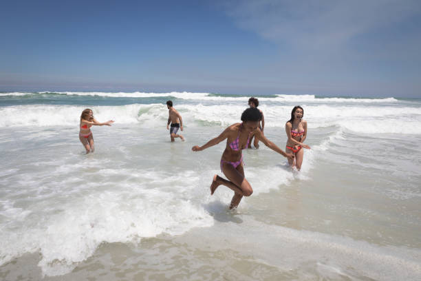istock Happy group of friends playing on ocean waves 1140139087