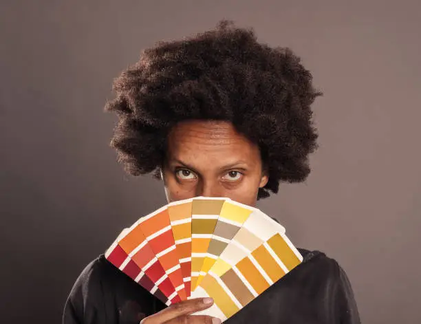 woman holding a color palette on a gray background